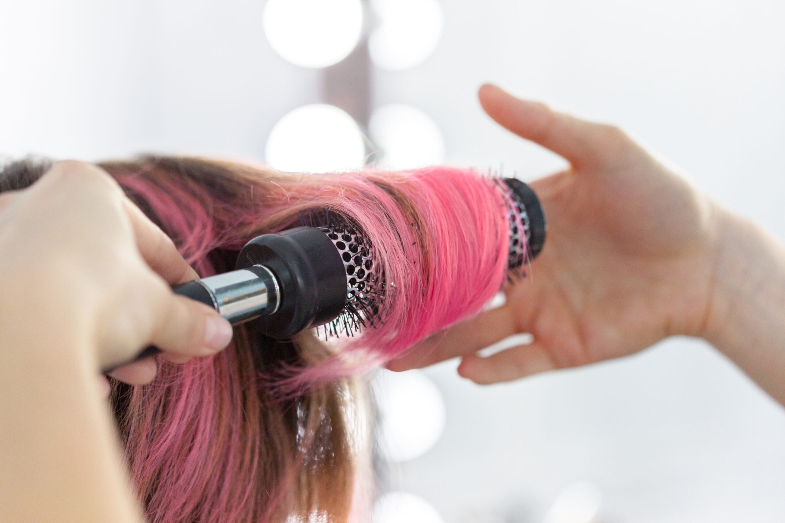 Hairdresser does hair style of woman